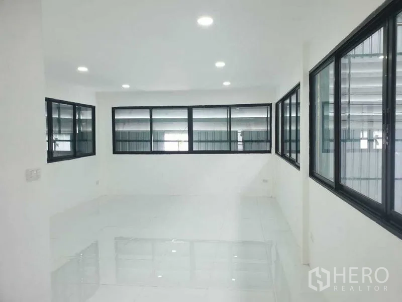 Warehouse for rent in Prawet, Bangkok - Large upper-floor office space with multiple windows and LED lighting.
