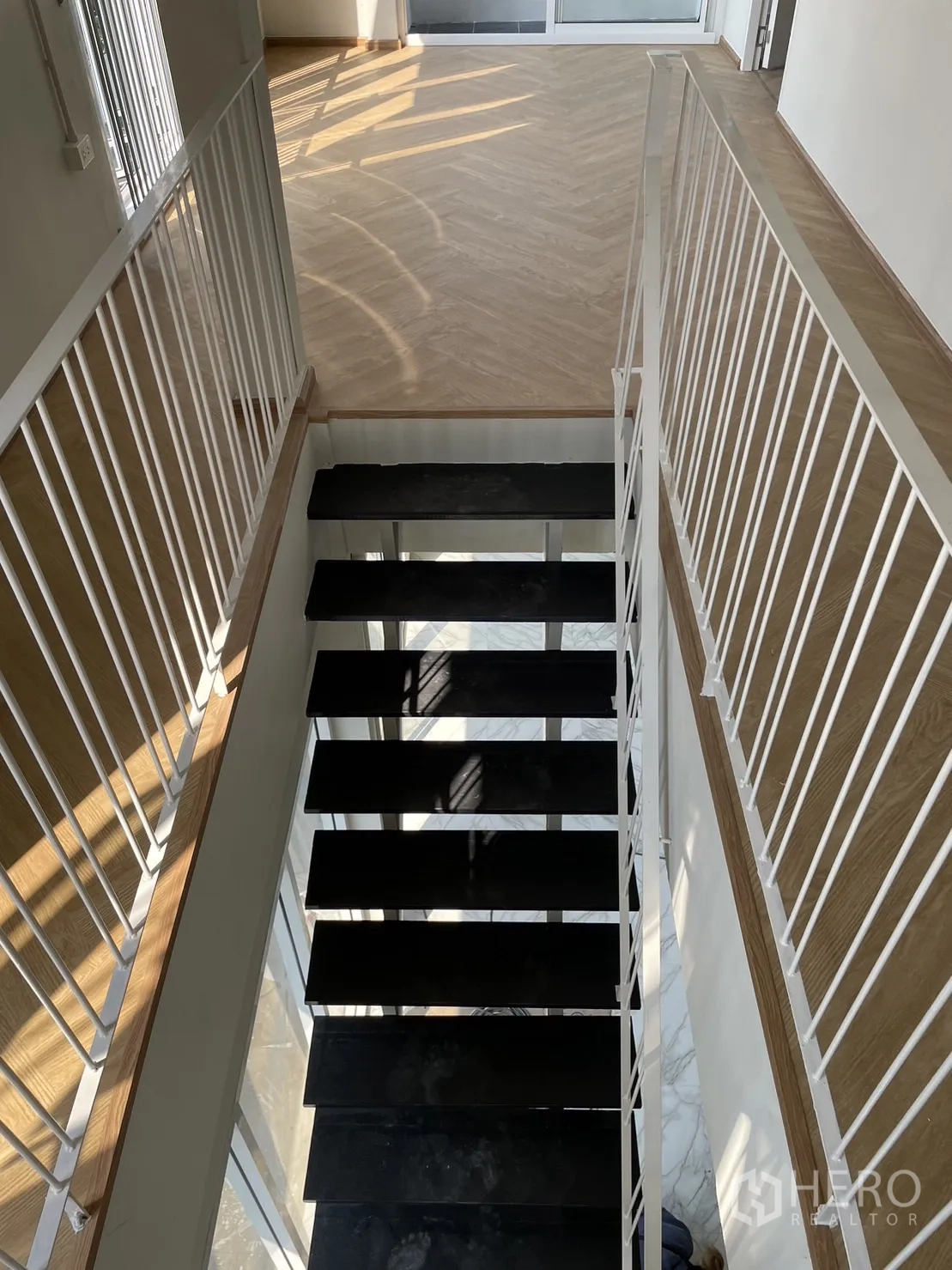 Detached House for rent or sale in Din Daeng, Bangkok - Staircase view with black treads and white railings leading to the ground floor.