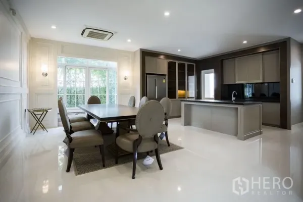 Detached House for rent in Mueang Samut Prakan, Samut Prakan - Open-plan dining area and modern island kitchen with built-in cabinetry and wide windows.