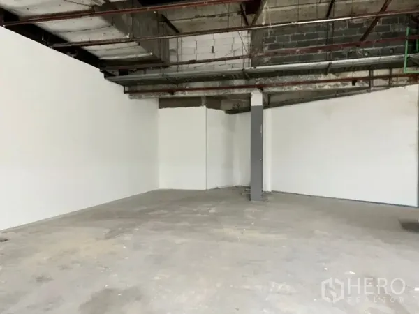 Retail Space for rent in Khlong Toei, Bangkok - Large retail area with white perimeter walls, a central column, and an exposed ceiling.