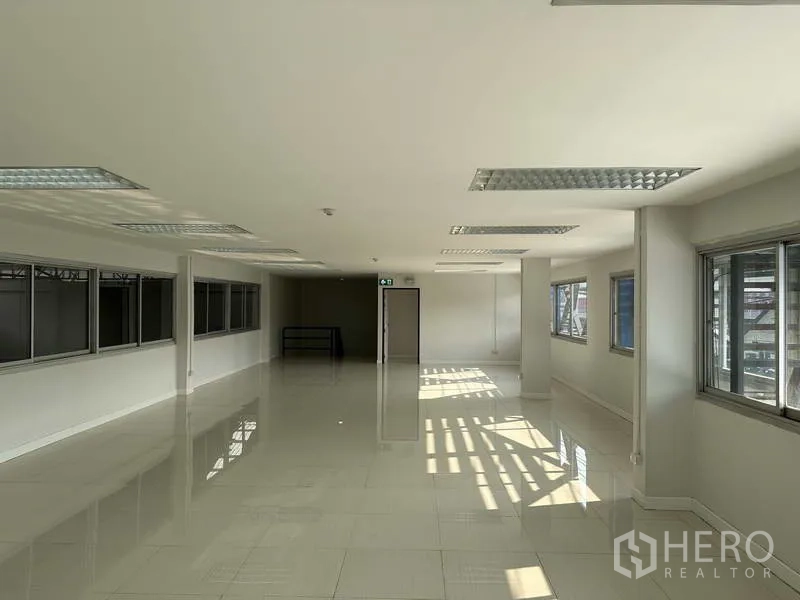 Factory for rent in Bang Phli, Samut Prakan - Open-plan office area with multiple windows, glossy tile floors and ample daylight.