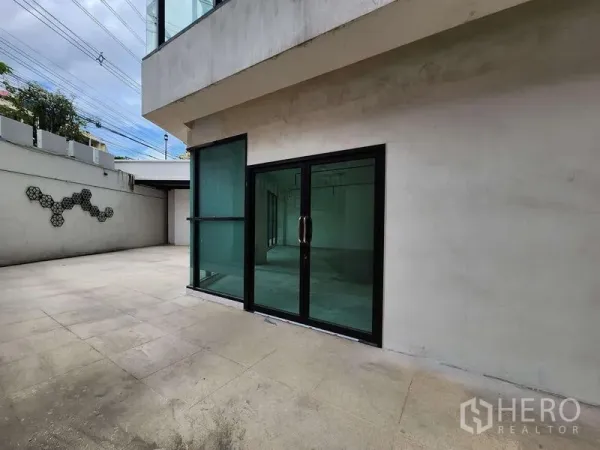 Retail Space for rent in Sathon, Bangkok - Ground-level terrace with wide tiled forecourt and black-framed glass entrance doors.