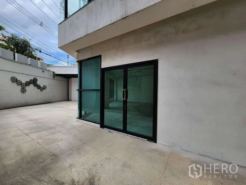 Retail Space for rent in Sathon, Bangkok - Ground-level terrace with wide tiled forecourt and black-framed glass entrance doors.
