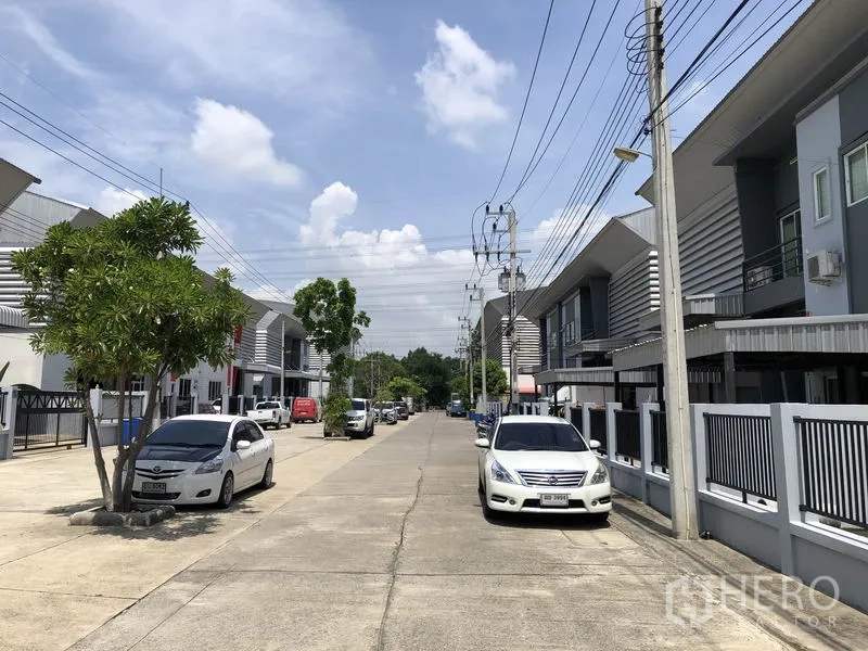 Factory for rent in Lam Luk Ka, Pathum Thani - Well‑kept industrial estate street lined with contemporary warehouses and utilities.