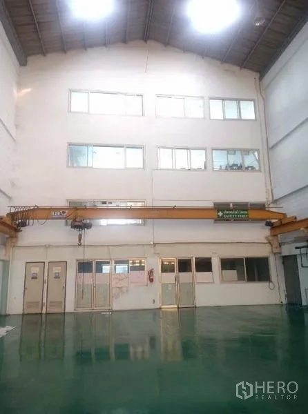Factory for sale in Khlong Luang, Pathum Thani - High-ceiling production hall with gantry crane and epoxy-coated floor.