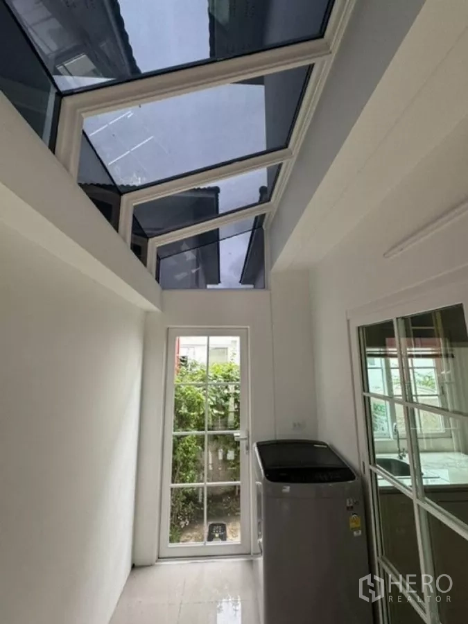 Detached House for rent in Thanyaburi, Pathum Thani - Covered utility zone with glass roof, washing machine and rear door to the garden.