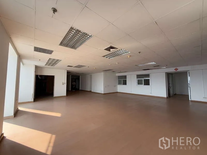 Office Space for rent in Chatuchak, Bangkok - Large unfurnished office floor with ceiling air vents, fluorescent lights and dual entry doors.