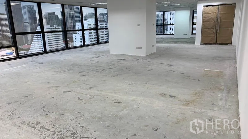 Office Space for rent in Ratchathewi, Bangkok - Unfurnished office space with concrete flooring and city-view glazing.
