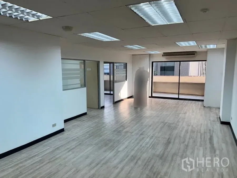 Office Space for rent in Pathum Wan, Bangkok - Bright open-plan office with wood-look floors, drop ceiling lights and sliding glass to a balcony.