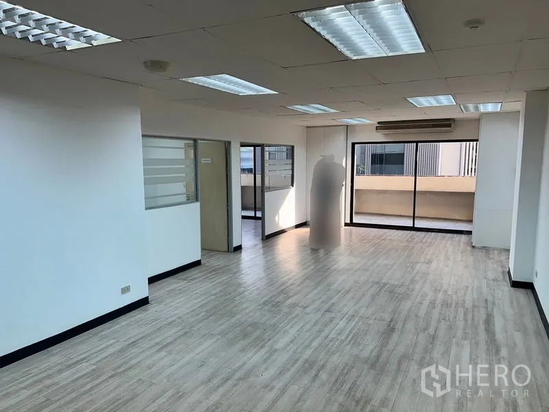 Office Space for rent in Pathum Wan, Bangkok - Bright open-plan office with wood-look floors, drop ceiling lights and sliding glass to a balcony.