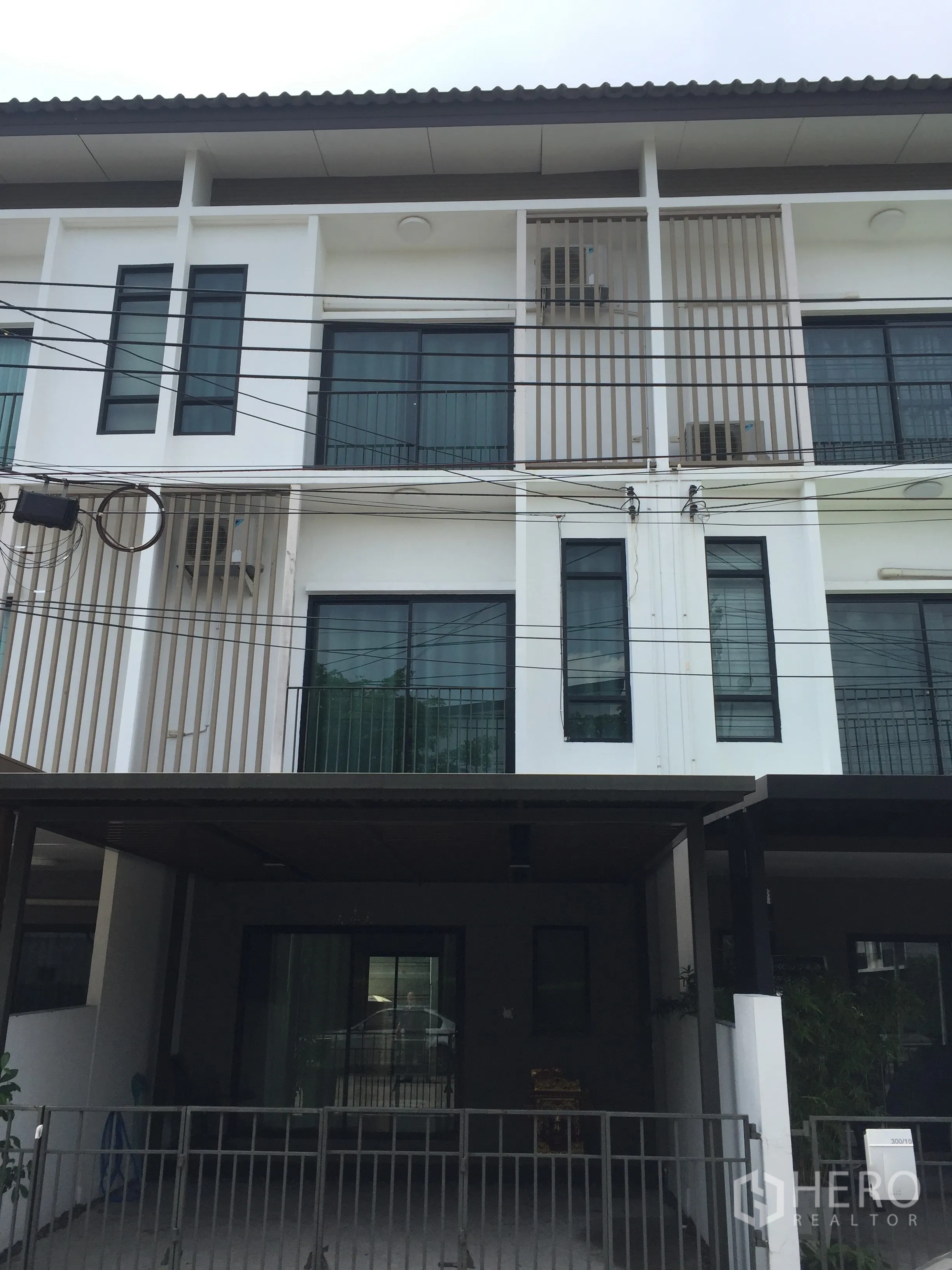 Townhouse for rent in Bang Kapi, Bangkok - Three-storey modern townhouse facade with balconies and a covered carport in Bang Kapi, Bangkok.