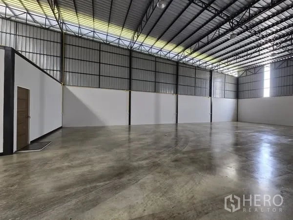 货栈 出租在Khlong Sam Wa, Bangkok - 挑高仓库大厅，金属墙体与采光带提供自然光。