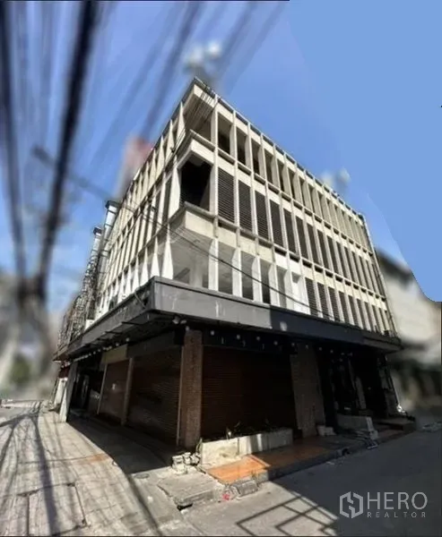 店屋 出租在Khlong Toei, Bangkok - 多层店屋转角外观，混凝土格栅立面与宽大的雨篷。