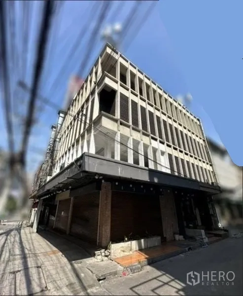 店屋 出租在Khlong Toei, Bangkok - 多层店屋转角外观，混凝土格栅立面与宽大的雨篷。
