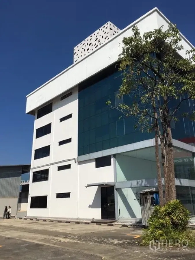 Warehouse for rent in Saphan Sung, Bangkok - Modern office building with blue glass facade beside warehouse in Saphan Sung, Bangkok.
