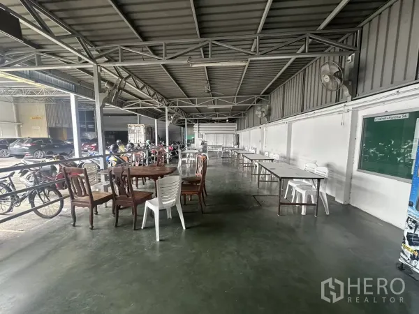 Warehouse for rent in Yan Nawa, Bangkok - Open-air staff canteen area with tables and chairs under a steel roof inside the warehouse grounds.