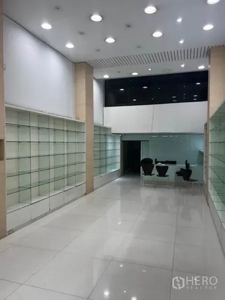 Shophouse for rent in Bang Rak, Bangkok - Ground-floor showroom with high ceiling, recessed lights and built-in glass display shelves.
