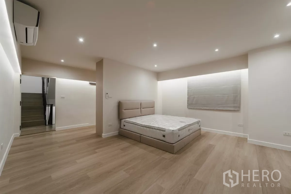 Townhouse for rent in Watthana, Bangkok - Spacious bedroom with platform bed, window shades and LED cove lighting.