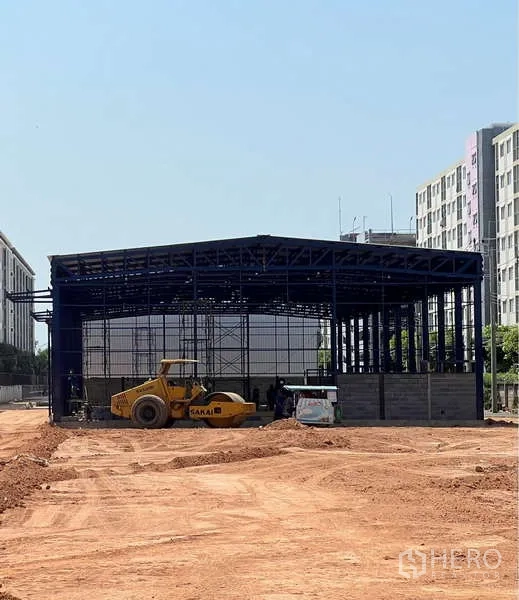 Warehouse for rent in Lat Krabang, Bangkok - Steel-frame warehouse under construction with a roller on compacted soil in Lat Krabang.