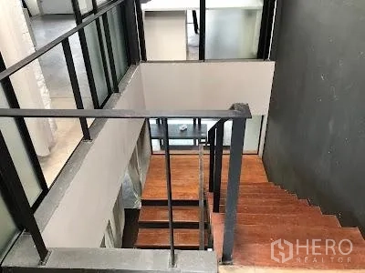 Home Office for rent in Watthana, Bangkok - Staircase with wooden treads and metal handrail, framed by glass partitions between levels.