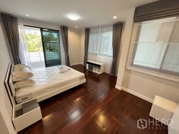 Detached House for rent in Phaya Thai, Bangkok - Corner master bedroom with large windows, curtains and balcony access.