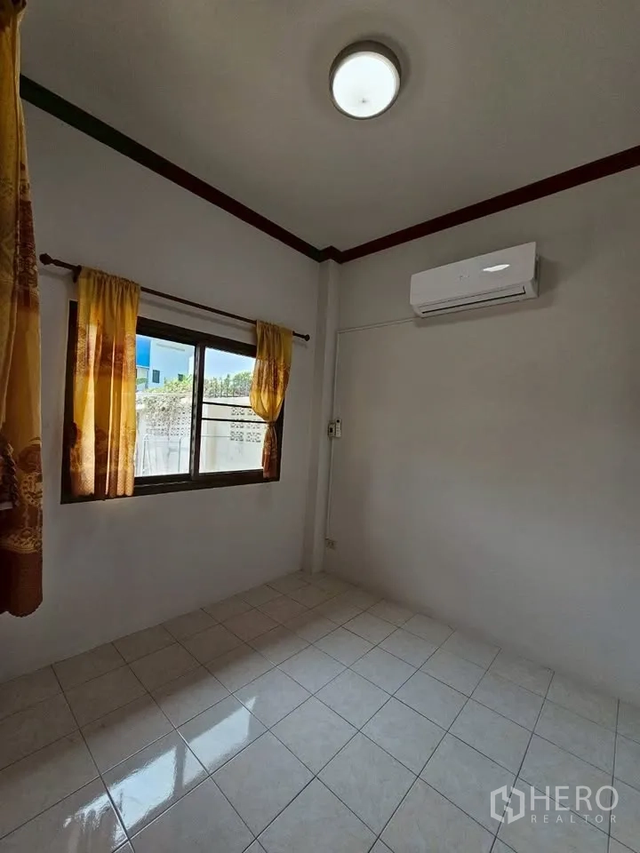 Home Office for rent in Wang Thonglang, Bangkok - Small tiled bedroom with window curtains and wall‑mounted air conditioner.