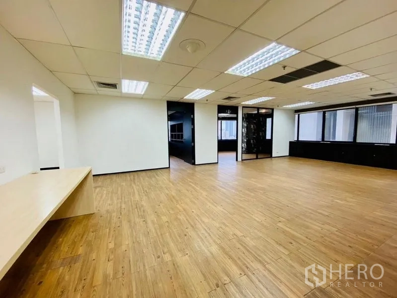 Office Space for rent or sale in Watthana, Bangkok - Spacious office area with built-in counter, large windows and fluorescent lighting.