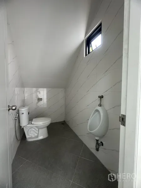 Warehouse for sale in Khlong Luang, Pathum Thani - Ground-floor restroom with toilet, urinal and marble-style wall tiles.