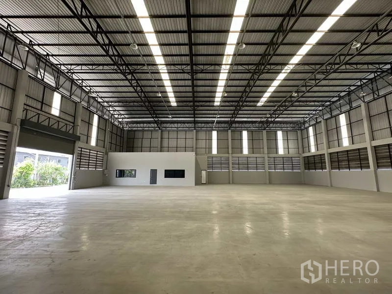 Warehouse for rent in Bang Phli, Samut Prakan - Warehouse hall with large roller shutter door and internal office block to the side.