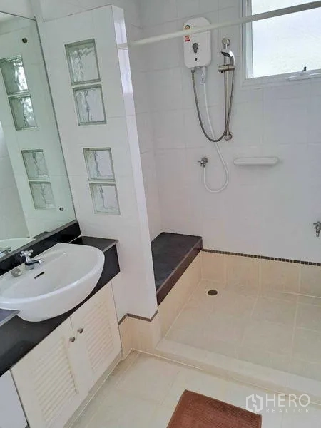 Detached House for rent in Prawet, Bangkok - Clean bathroom with walk-in shower, water heater and vanity with mirror.
