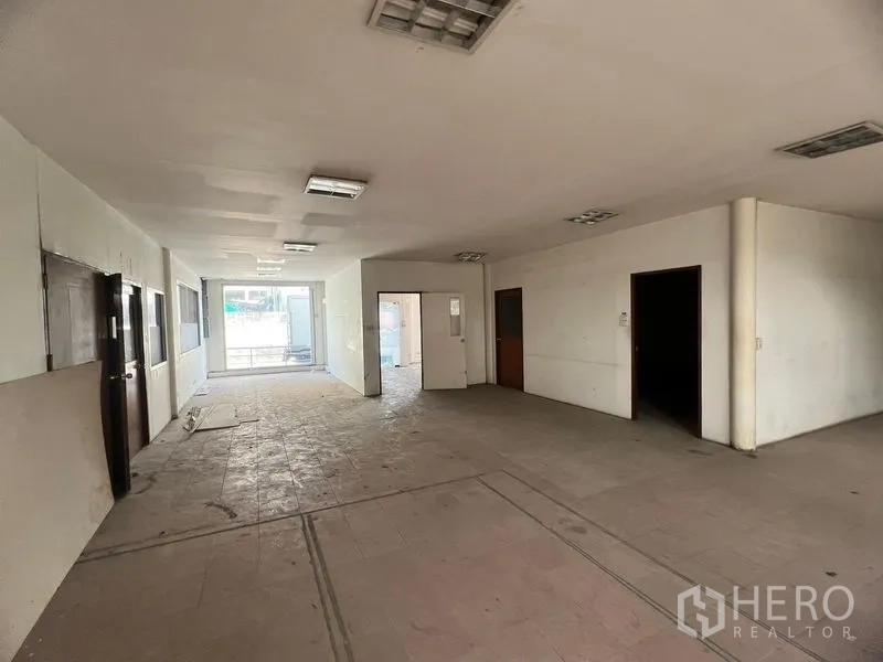 Warehouse for rent in Suan Luang, Bangkok - Ground-floor office area inside the warehouse with partitioned rooms, tiled floors and fluorescent lighting.