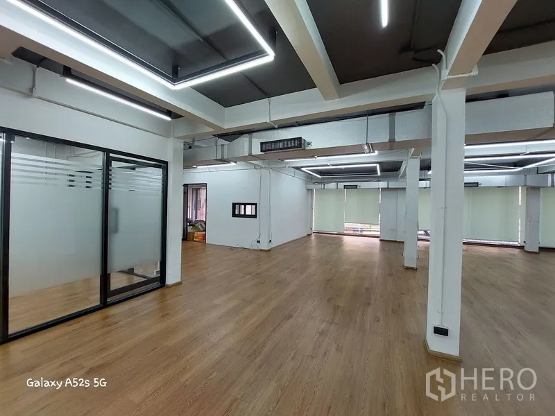 带办公室的家 出租在Khlong Toei, Bangkok - 明亮办公室区域，带玻璃房、深色天花与几何LED灯。
