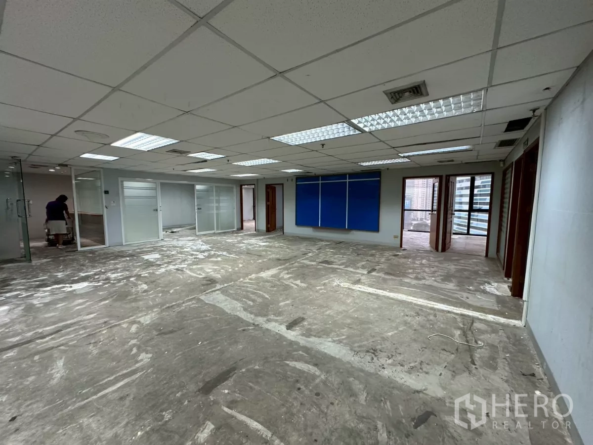Office Space for rent in Khlong Toei, Bangkok - Spacious open-plan workspace with suspended ceiling lights and glass-partitioned rooms.