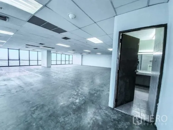 Office Space for rent in Din Daeng, Bangkok - Open-plan 300 sqm office with drop-ceiling lighting, expansive corner windows and an internal restroom entrance.