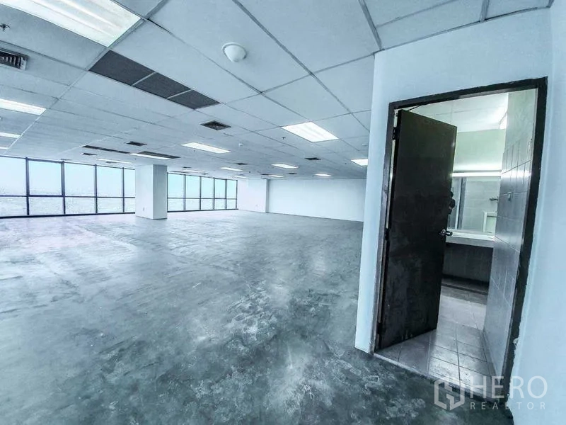 Office Space for rent in Din Daeng, Bangkok - Open-plan 300 sqm office with drop-ceiling lighting, expansive corner windows and an internal restroom entrance.