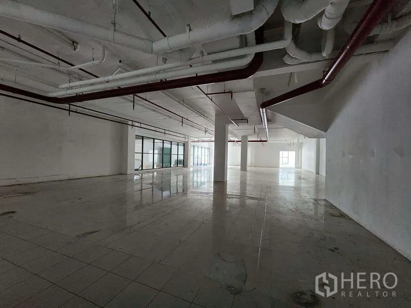 Retail Space for rent in Sathon, Bangkok - Expansive retail floor with tiled surface and exposed ceiling pipes ready for fit-out.
