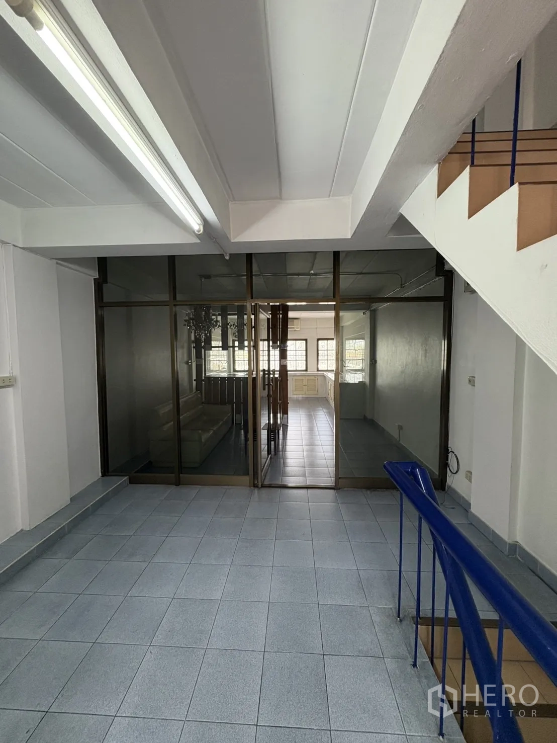 Shophouse for rent in Phra Khanong, Bangkok - Landing area with glass sliding partitions separating another room.