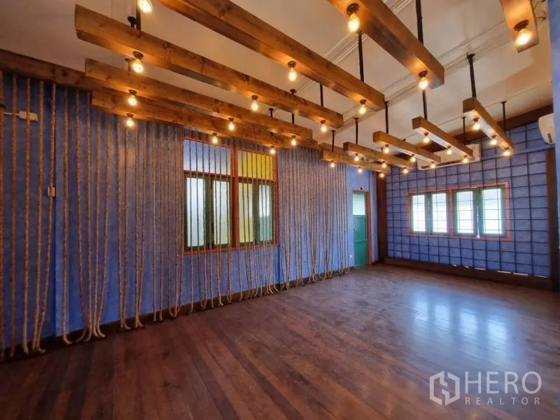 Detached House for rent in Khlong Toei, Bangkok - Spacious upper room with rope accents and exposed timber beams with bulbs.