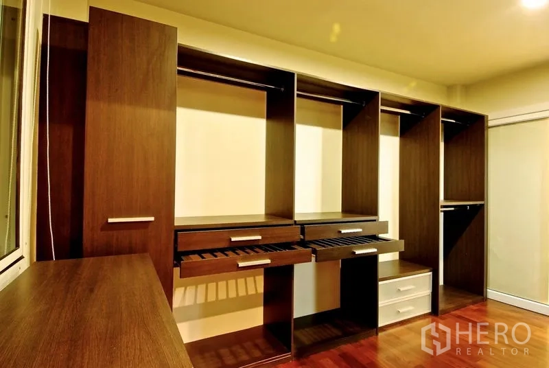 Detached House for rent in Watthana, Bangkok - Walk‑in closet with built‑in wooden wardrobes, drawers and shelves.