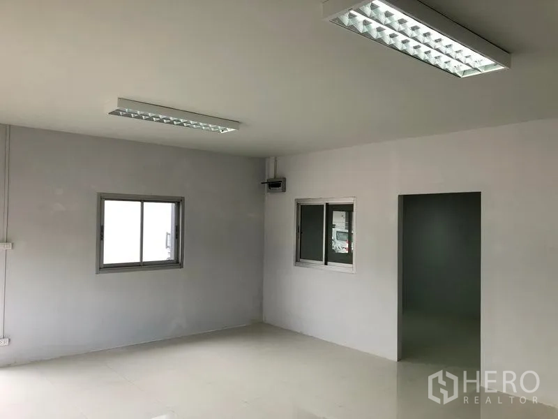 Warehouse for rent in Khlong Luang, Pathum Thani - Bright office area with windows, doorway and tiled flooring connected to the warehouse.