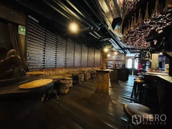 Retail Space for rent in Watthana, Bangkok - Spacious lounge area with long tufted banquette, high tables, dark wood floors and exposed ceiling.