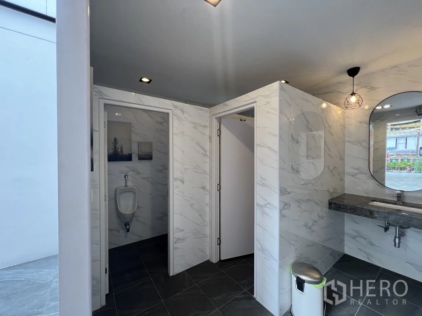 Retail Space for rent - Modern restrooms with marble-look wall tiles, vanity and separate stalls.