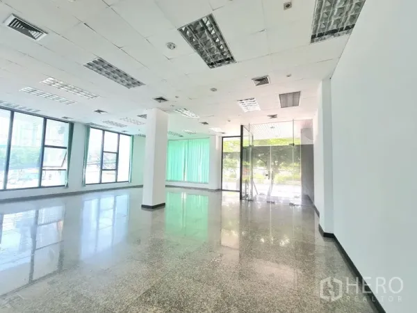 Retail Space for rent in Sathon, Bangkok - Bright corner of the shop with glass entrance doors, ceiling lighting, and tall windows fitted with green vertical blinds.