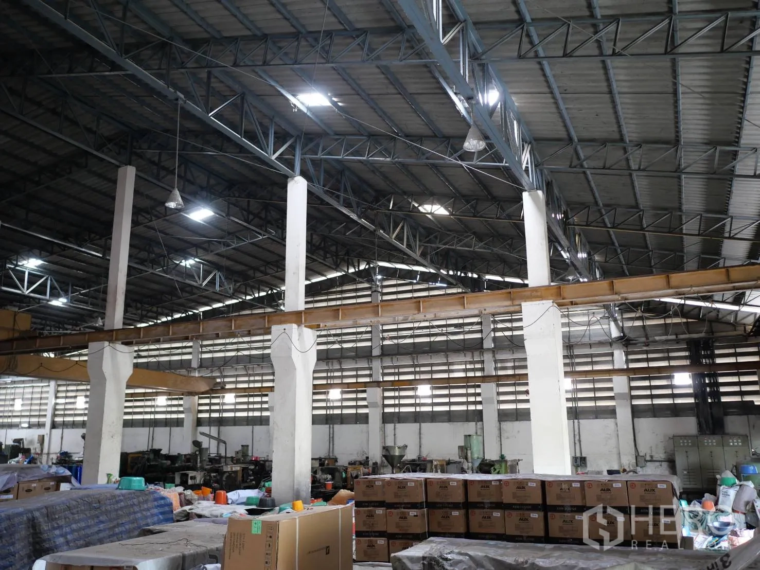 Factory for rent or sale in Bang Khun Thian, Bangkok - Steel truss roof with skylights above a spacious open factory floor.