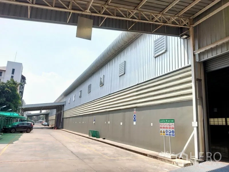 Warehouse for rent in Phaya Thai, Bangkok - Long driveway beside the warehouse with ventilation louvres and parking area.