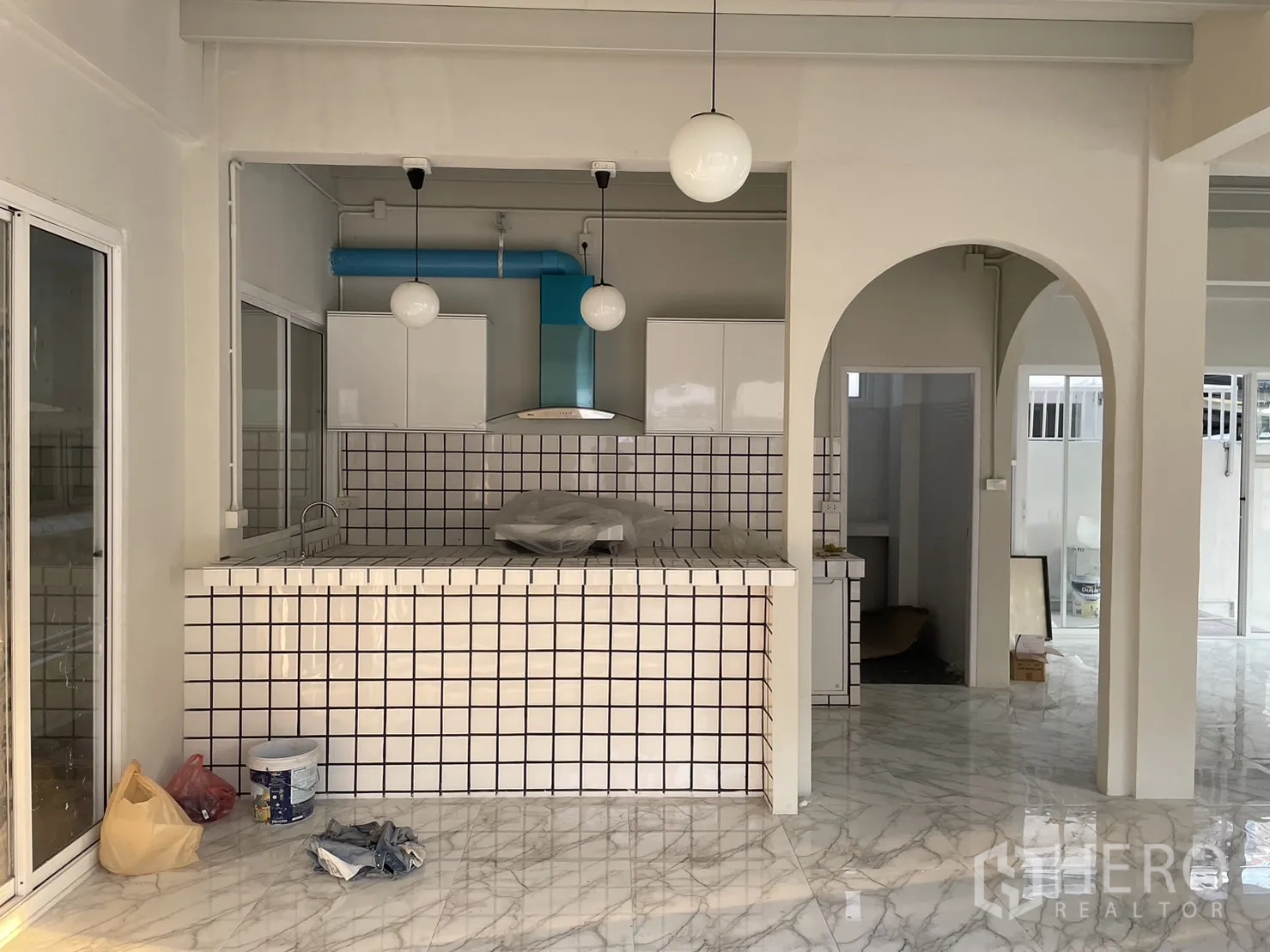 Detached House for rent or sale in Din Daeng, Bangkok - Open kitchen with tiled island, hanging globe lights and blue ventilation duct.