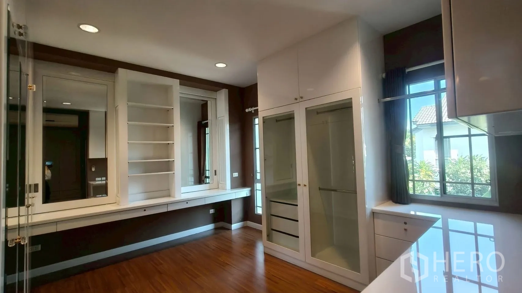 Detached House for rent or sale in Mueang Samut Prakan, Samut Prakan - Walk-in dressing room with built-in wardrobes, shelving, large mirrors and wood flooring.