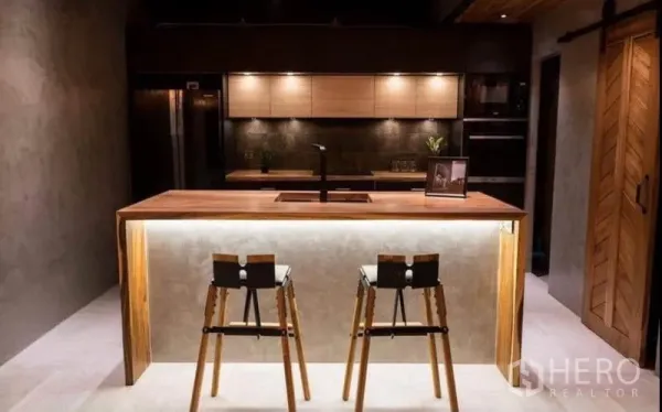 Townhouse for rent in Khlong Toei, Bangkok - Designer kitchen with illuminated island, wooden countertop and two bar stools.
