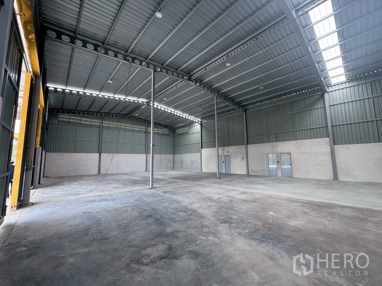 Warehouse for rent in Khlong Luang, Pathum Thani - Wide warehouse bay with high roof, concrete slab flooring and multiple access doors.
