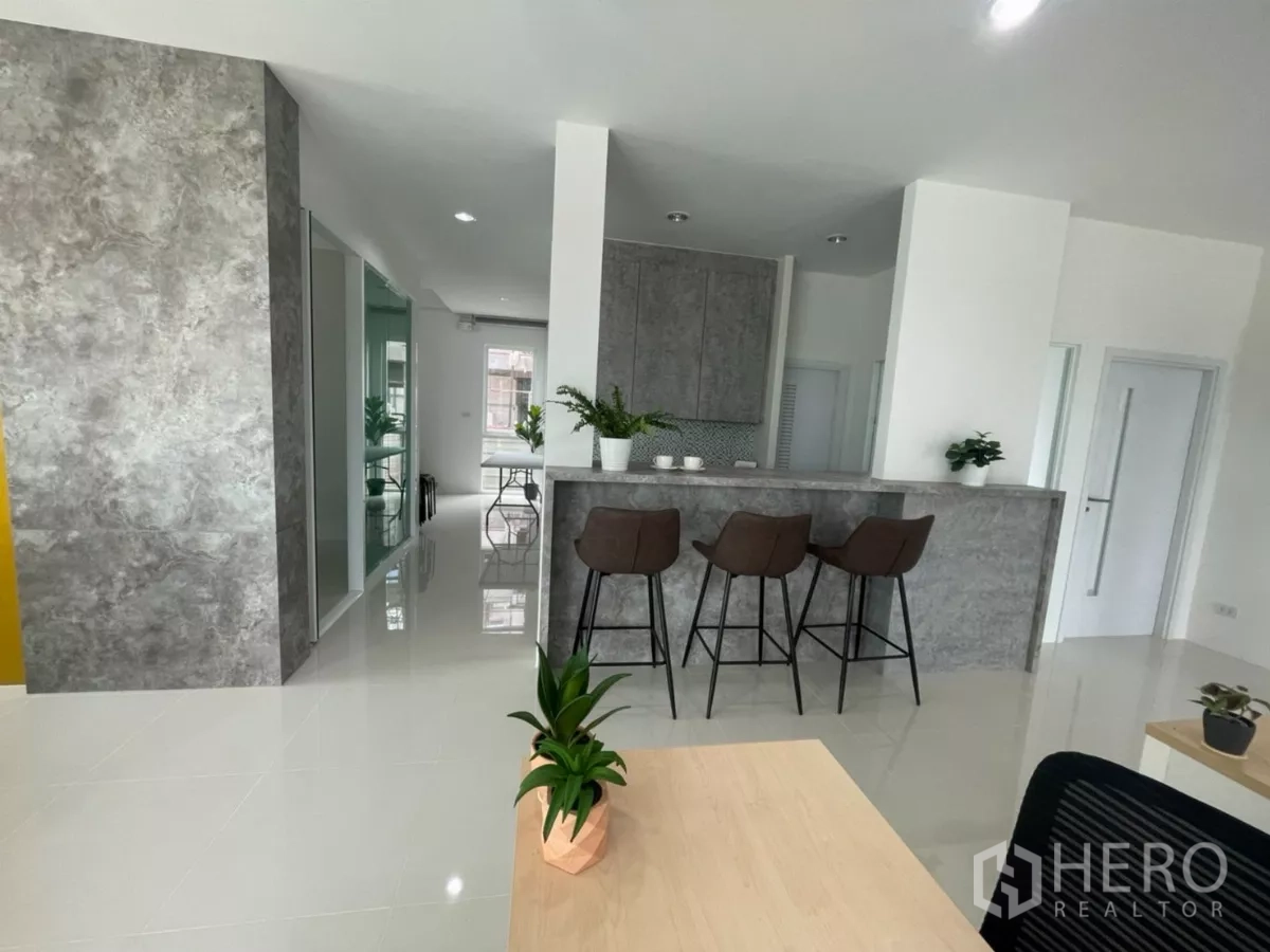 Warehouse for sale in Lam Luk Ka, Pathum Thani - Sleek office interior with breakfast bar, stools and glossy tiled floor.
